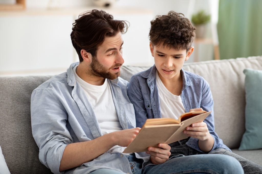 Father and son reading a book together